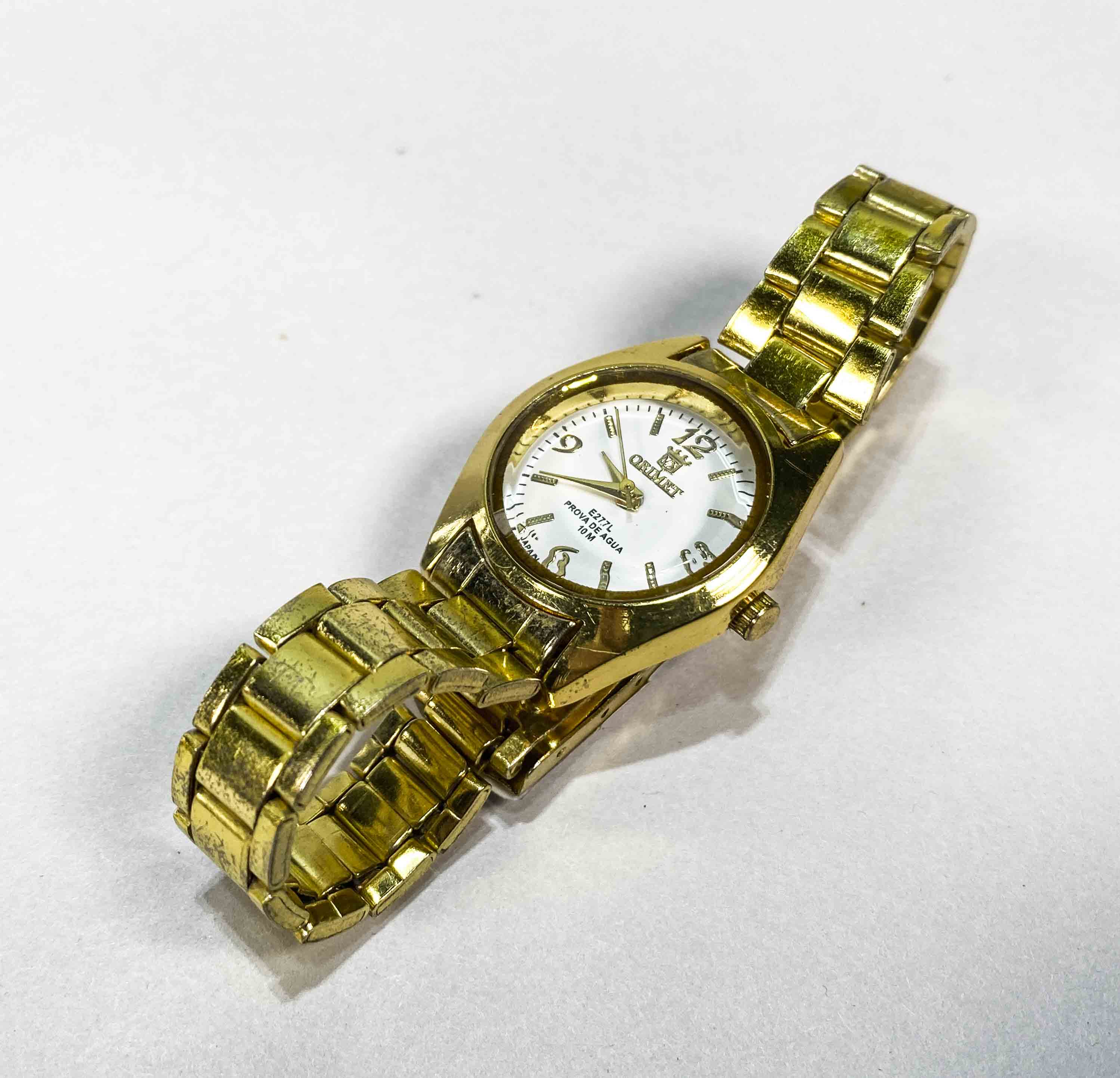 Un reloj de dama dice ORIENT color dorado esfera blanca con